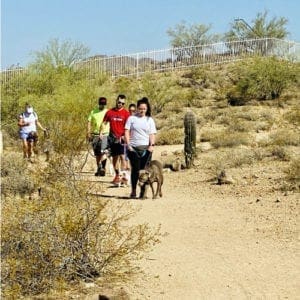 Pet parents and their dogs practice leash manners and crowd walking as part of FurBabies & Friends Canine Good Citizen prep dog training class.
